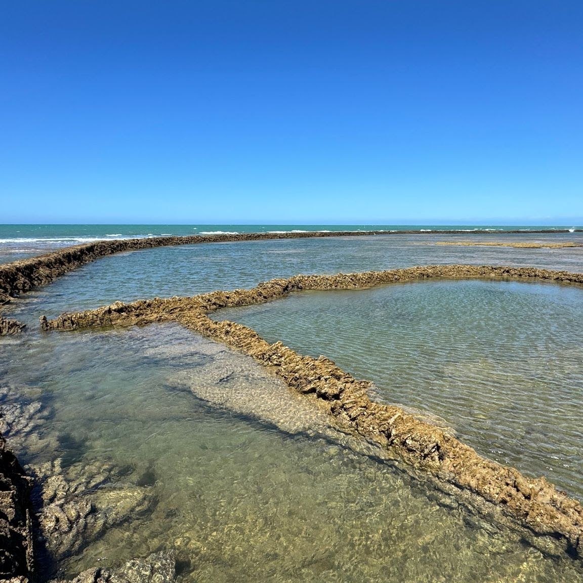 Walls of the corrales and clear tidal pools at low water